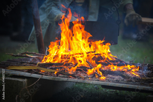 Burning firewood at campfire.