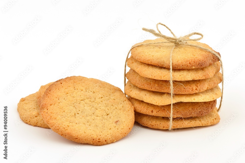 Homemade peanut butter cookies. A stack tied with twine and some loose by the side. On white.