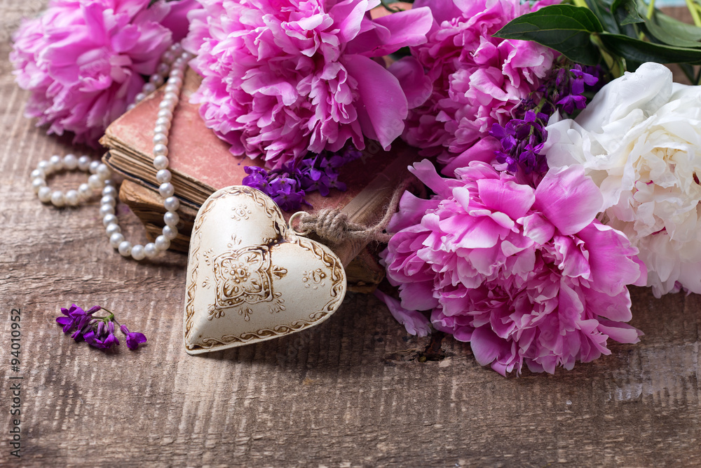 Decorative heart and splendid  pink  and white peonies flowers on aged wooden background.Vintage background.  Selective focus. .