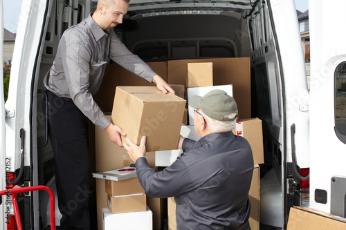 Group of delivery men near shipping truck. © grinny