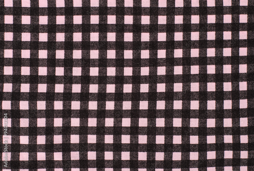 Close up on checkered tablecloth fabric. Black and pink tartan square pattern as background.