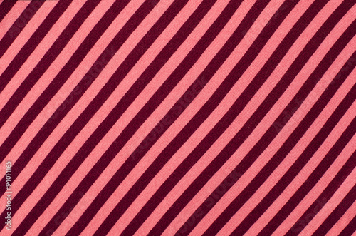 Striped pink and red textile pattern as a background. Close up on diagonal stripes material texture fabric.