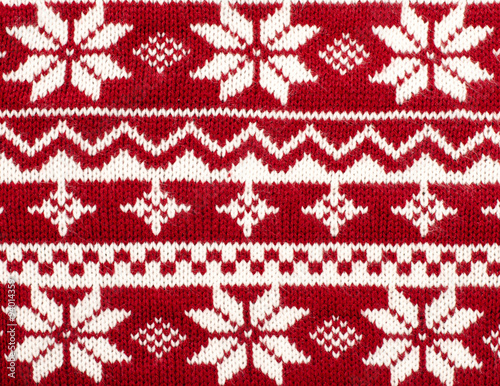 Close up on knit woolen texture. Winter snowflakes shapes pattern background.