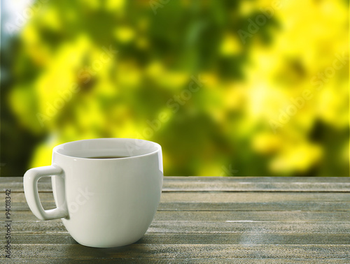 Cup of coffee on table on bright background