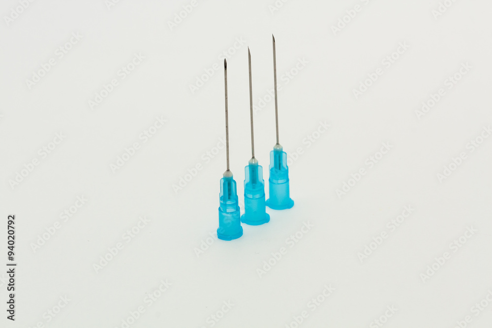 Three blue disposable syringe needles in a line Three blue disposable syringe needles in a line