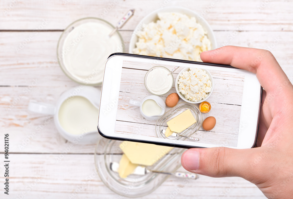 Hands taking photo dairy products with smartphone. Hands taking photo dairy products with smartphone.