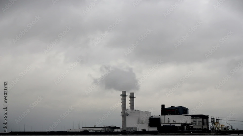 Thick smoke flowing out of a high factory chimney on a stormy day. Thick smoke flowing out of a high factory chimney on a stormy day.