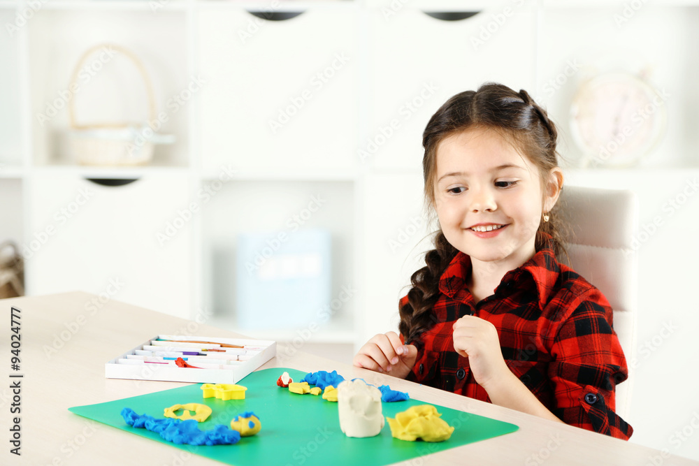 Cute little girl moulds from plasticine on table Cute little girl moulds from plasticine on table