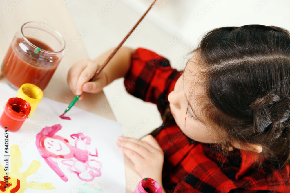 Cute little girl painting picture on home interior background Cute little girl painting picture on home interior background
