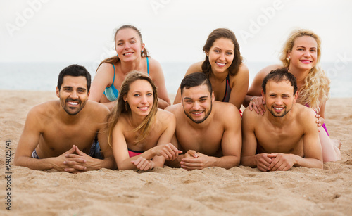 Friends laying on sand at beach