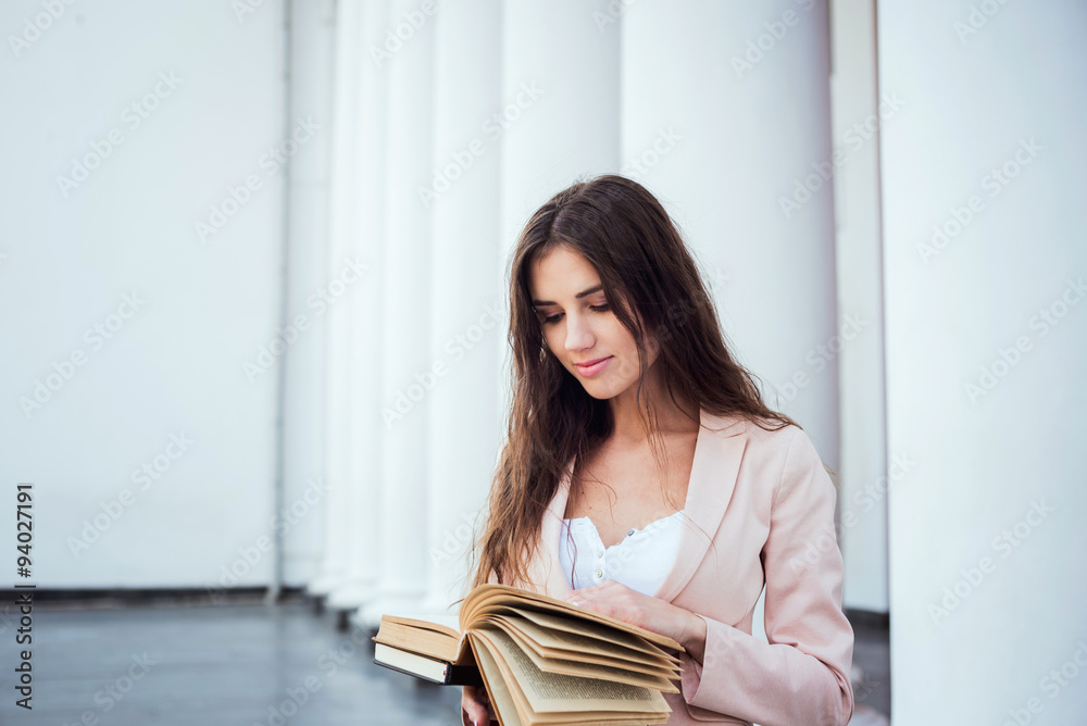 young caucasian female student with books on campus, student study in campus area young caucasian female student with books on campus, student study in campus area