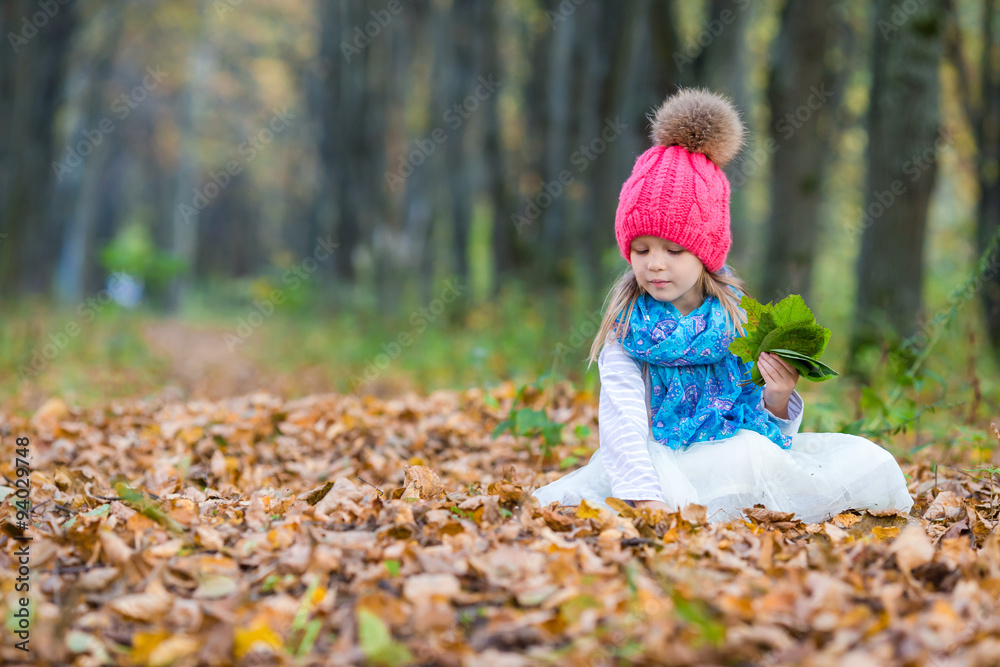Adorable little girl outdoors at beautiful warm day in autumn