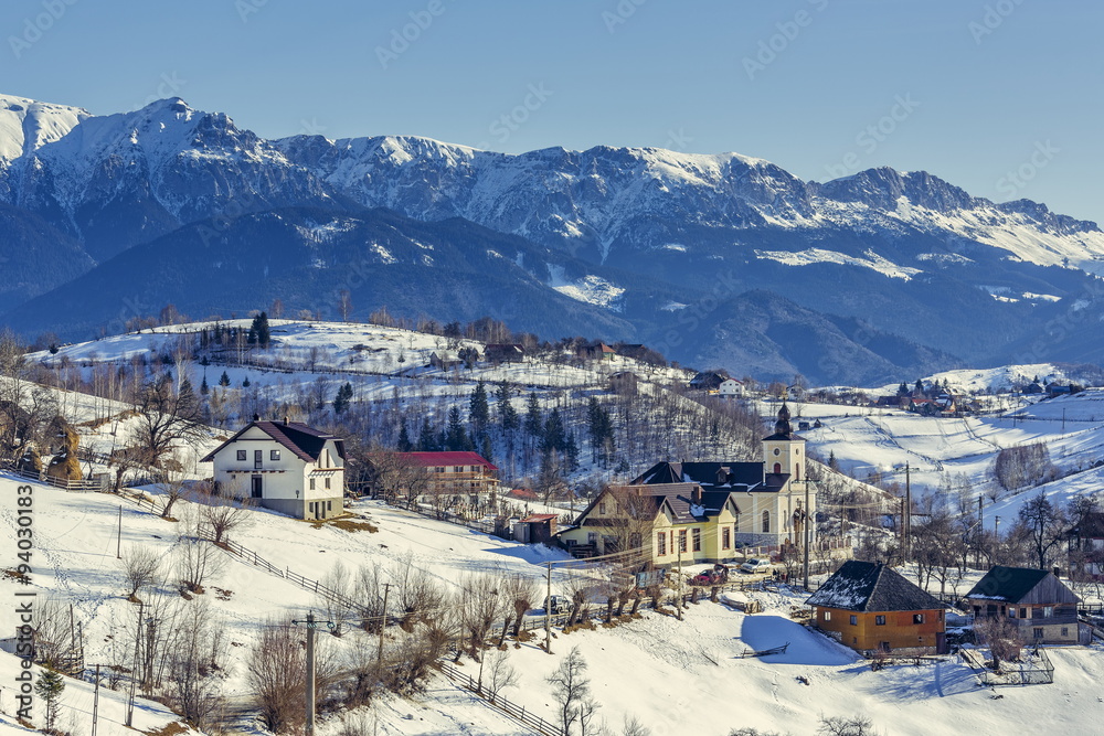 Wintry rural mountain scenery in the valleys of Bucegi mountains in Magura village, Brasov county, Romania. Touristic destinations for winter vacation.