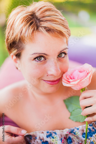 Cute young woman holding one rose