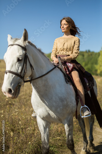 Beautiful girl riding a white horse