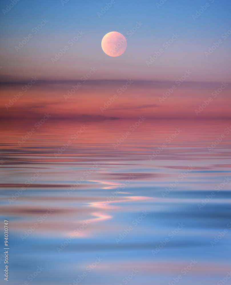 Pink moon with reflection in the sea