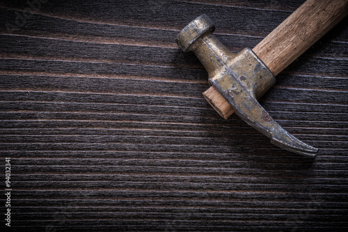 Rusty claw hammer on vintage wooden board construction concept photo