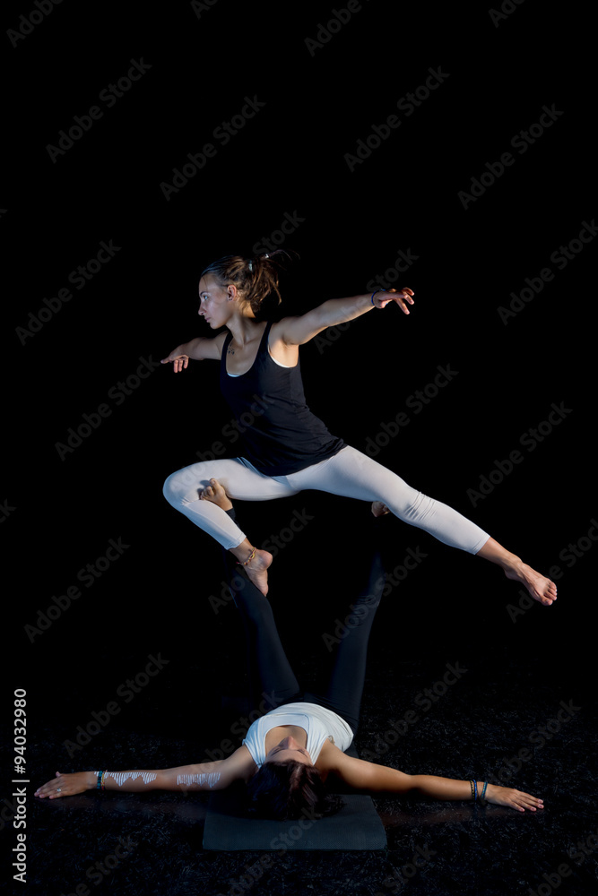 two girls performing acro-yoga poses