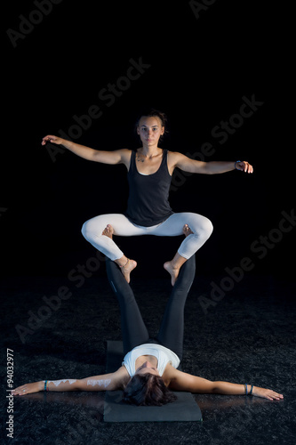 two girls performing acro-yoga poses
