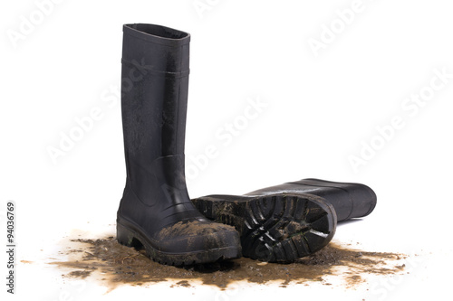 Muddy rubber boots front view isolated on white background