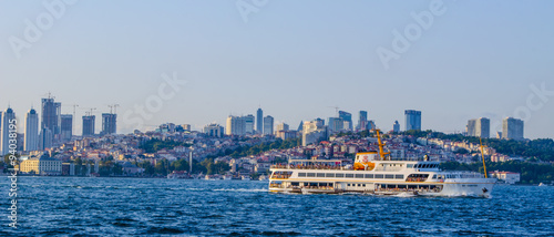 ferry is crossing bosphorus strait with istanbul city behind it. photo