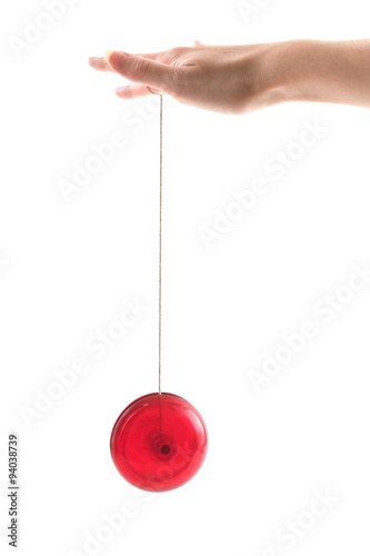 A hand holding a red yoyo as it goes up and down, isolated on white.