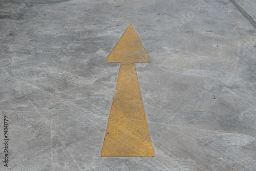 Yellow arrow on cement floor