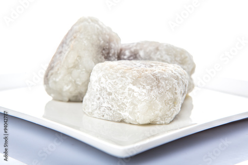 Japanese confection, round glutinous rice stuffed with sweetened red bean paste or locally known as daifukumochi in a white plate over white background