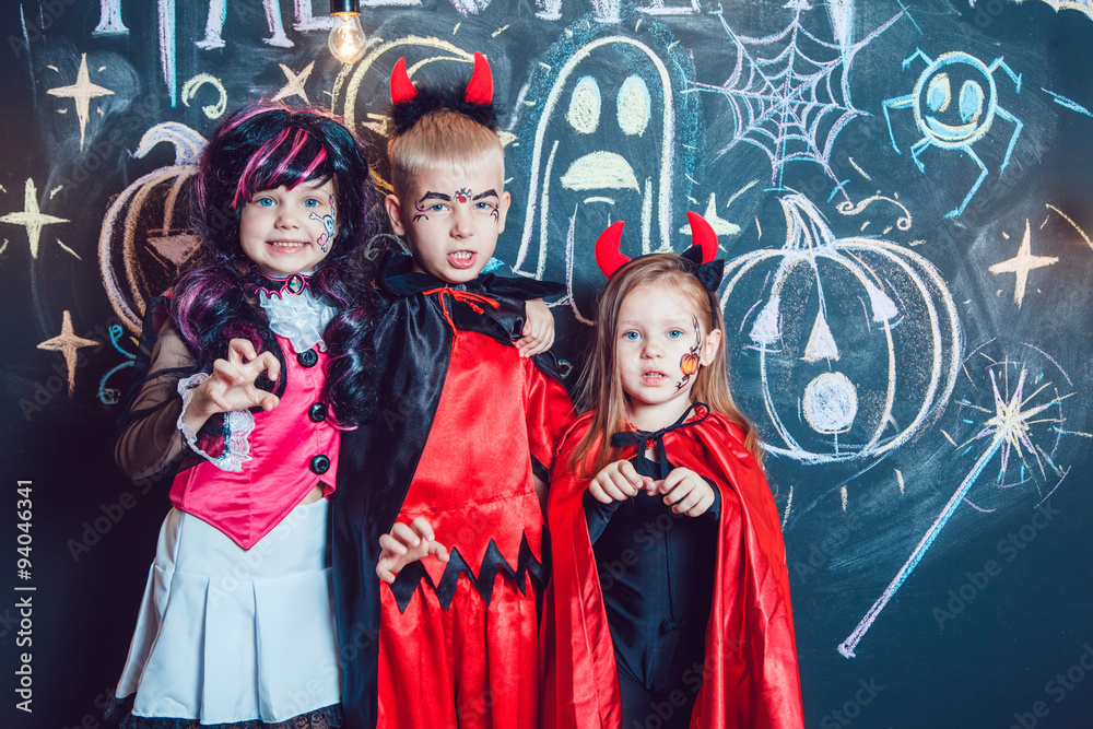 Fototapeta premium Girls, dressed up in Halloween costumes, show emotions of witches . Halloween party with group children.