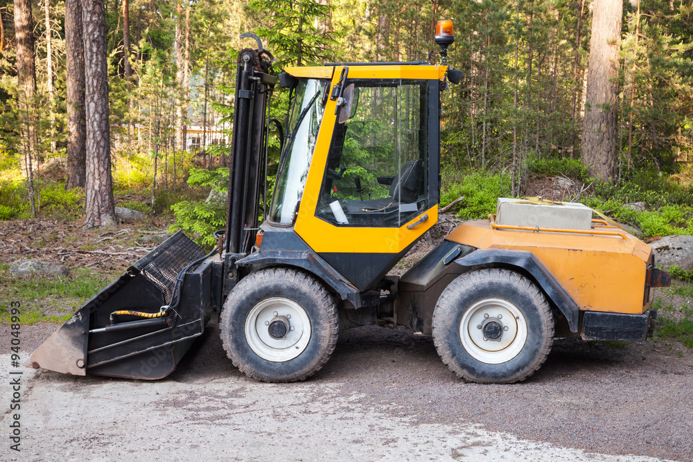 Yellow forklift with general bucket stands Yellow forklift with general bucket stands