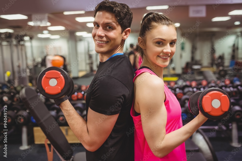 Fototapeta premium Fit couple lifting dumbbells together