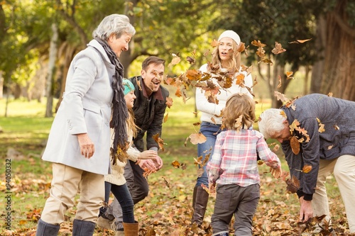 Fényképezés Happy extended family throwing leaves around