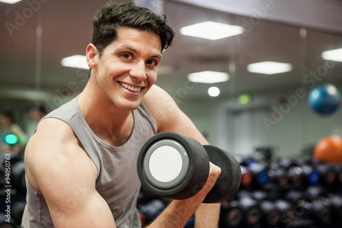 Smiling man lifting dumbbell weight