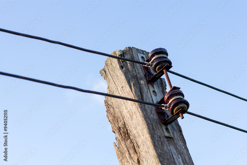 Obraz premium Power line conductor on old wooden pole