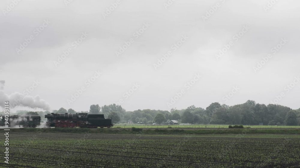 Old steam locomotive pulling railroad cars in the countryside. Old steam locomotive pulling railroad cars in the countryside.
