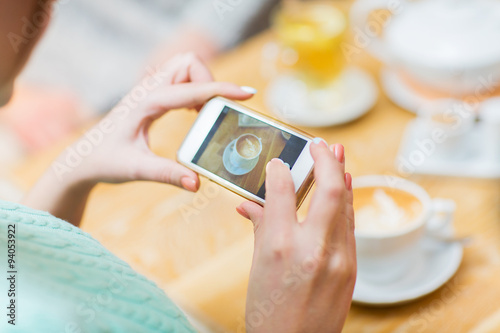 close up of woman smartphone picturing coffee cup