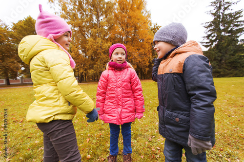 group of happy children talking in autumn park