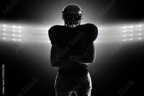 Composite image of silhouette american football player standing