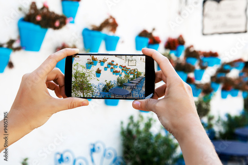 Female hands taking a picture with mobile phone in a white village in Andalusia, Spain. photo