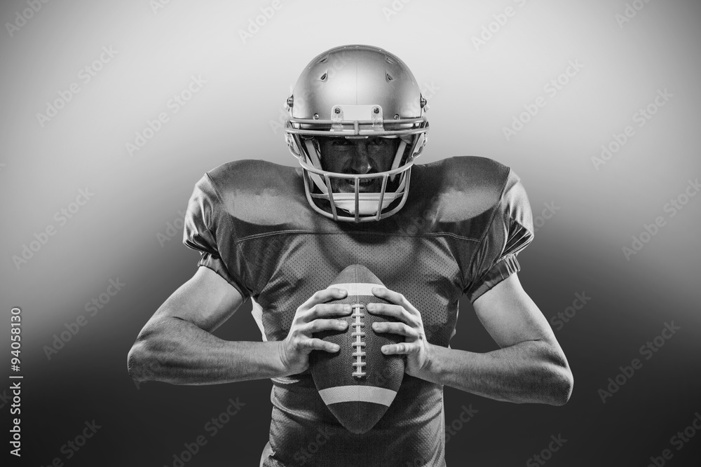 American football player in red jersey and helmet holding ball