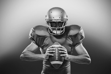 American football player in red jersey and helmet holding ball
