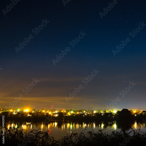 Stars in the night sky on a background city lighting. 