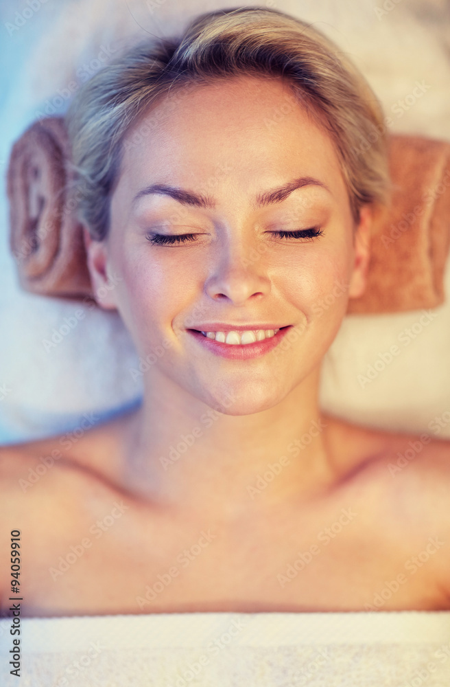 close up of smiling young woman lying in spa