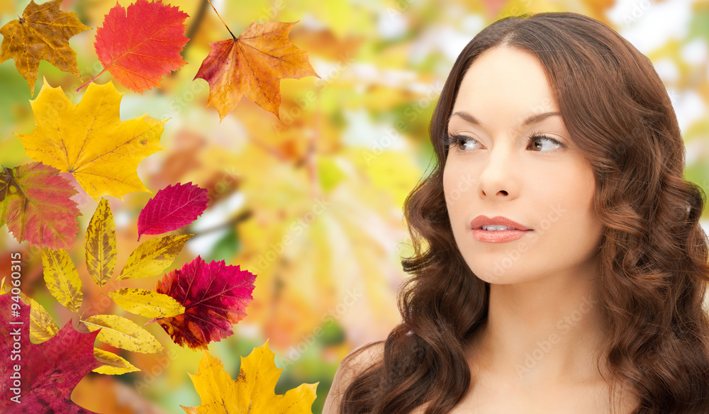beautiful young woman face over autumn leaves beautiful young woman face over autumn leaves