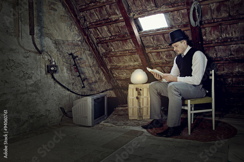Vintage Man Reading Book in Old Attic © Peter Nanista