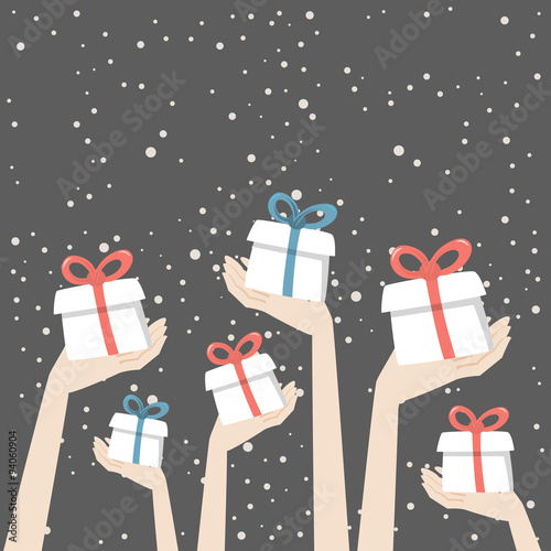 Hands are holding christmas presents with red and blue ribbons on the snowing background.