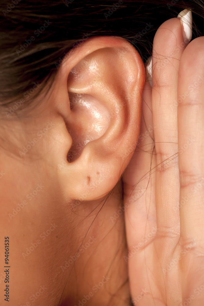 woman's ear with a hand behind woman's ear with a hand behind