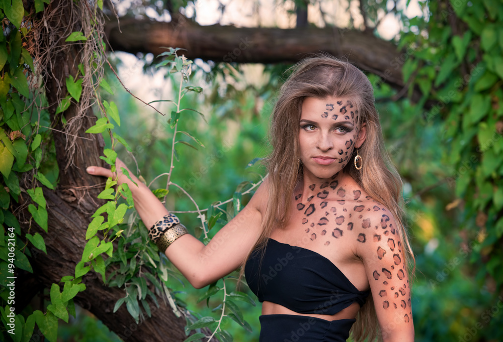 Portrait of a pretty blond woman in wild cat makeup in the trees Portrait of a pretty blond woman in wild cat makeup in the trees