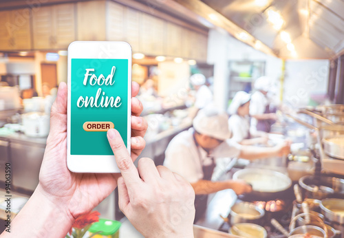 Hand holding mobile with Order food online with blur restaurant