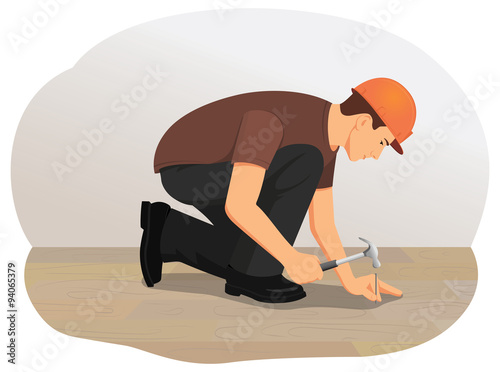 Handyman hammering a nail into wood. Installing wooden flooring.